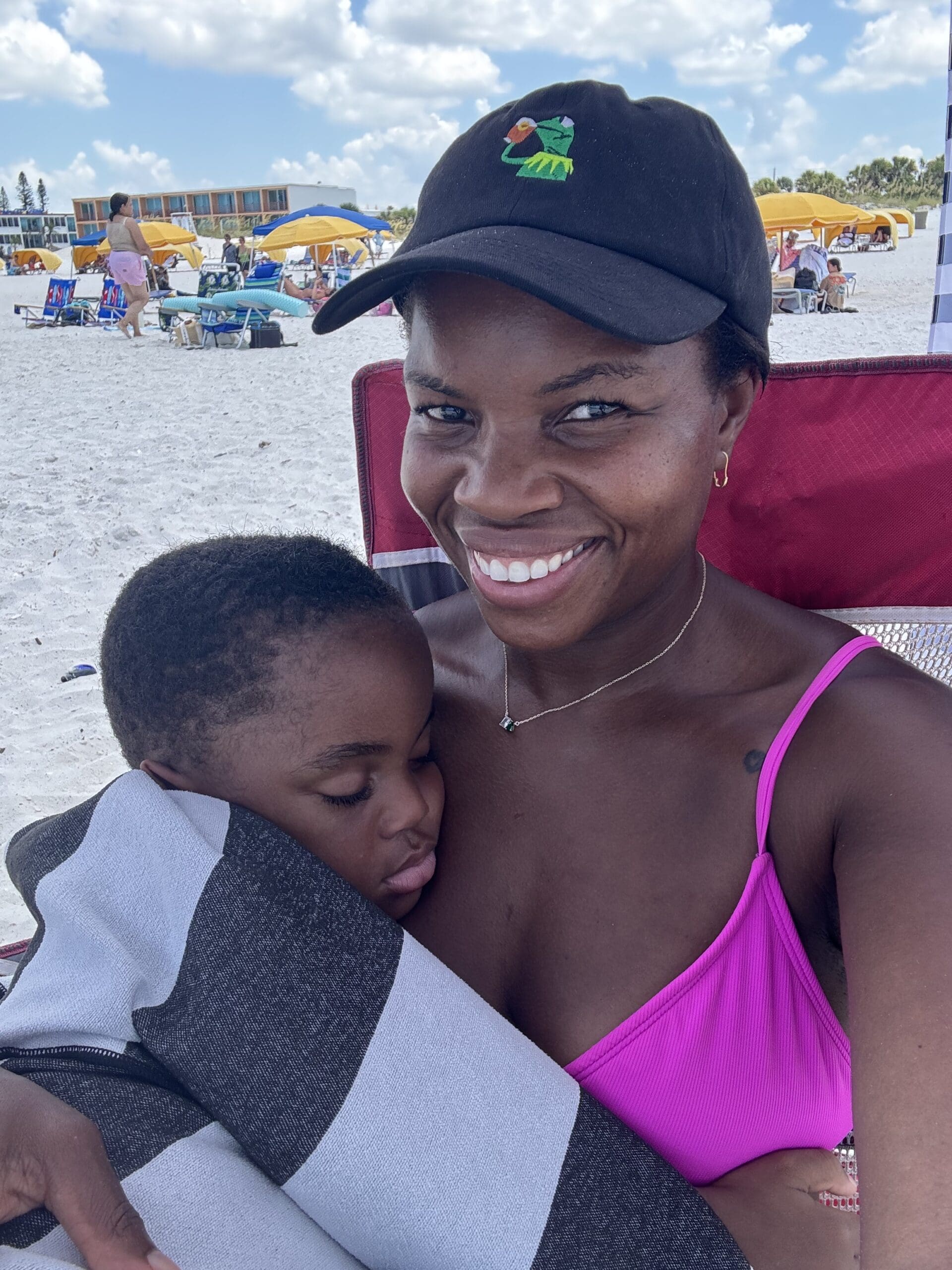 career coach holding baby son on the beach